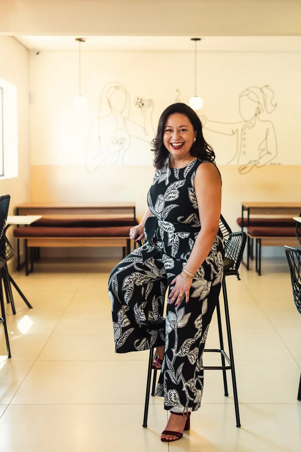 Wycisláudia Brandão sorrindo, sentada numa cafeteria